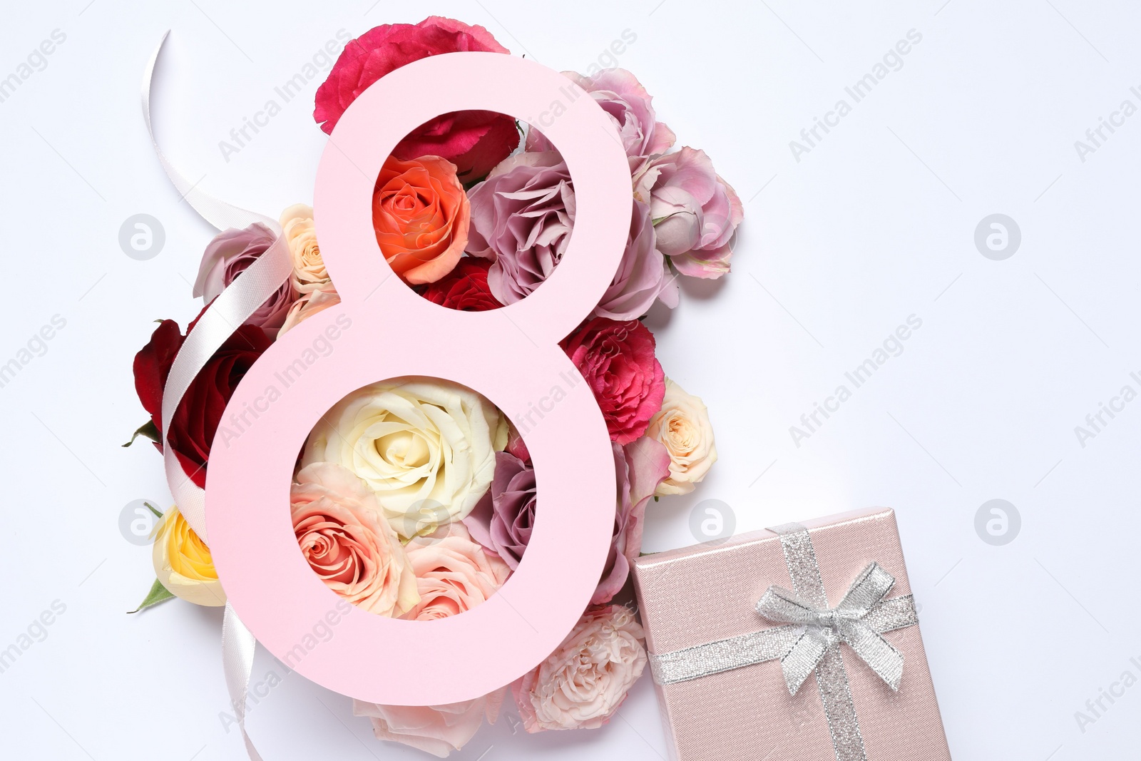 Photo of 8 March greeting card design with roses and gift box on white background, top view. Happy International Women's Day