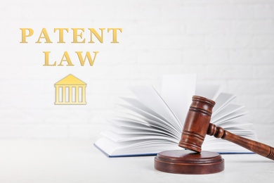 Image of Gavel and book on table against white background, space for text. Patent Law