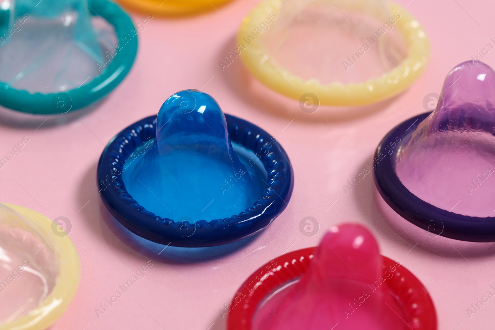 Photo of Condoms on pink background, closeup. Safe sex