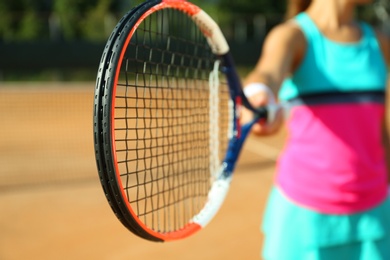 Photo of Sportswoman playing tennis at court on sunny day, closeup