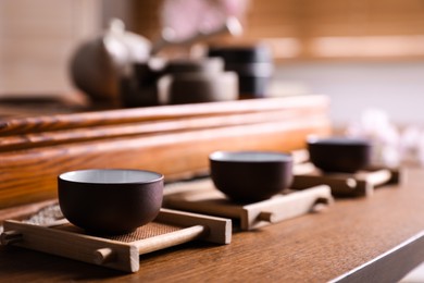 Photo of Cups for traditional tea ceremony on wooden table