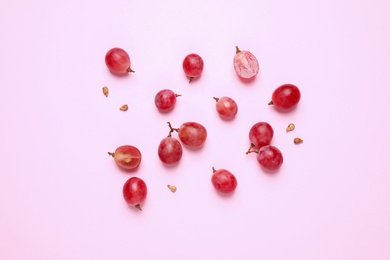 Flat lay composition with fresh ripe grapes and seeds on pink background