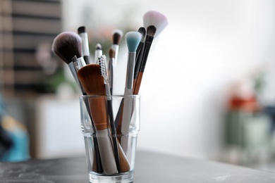 Photo of Holder with makeup brushes on table