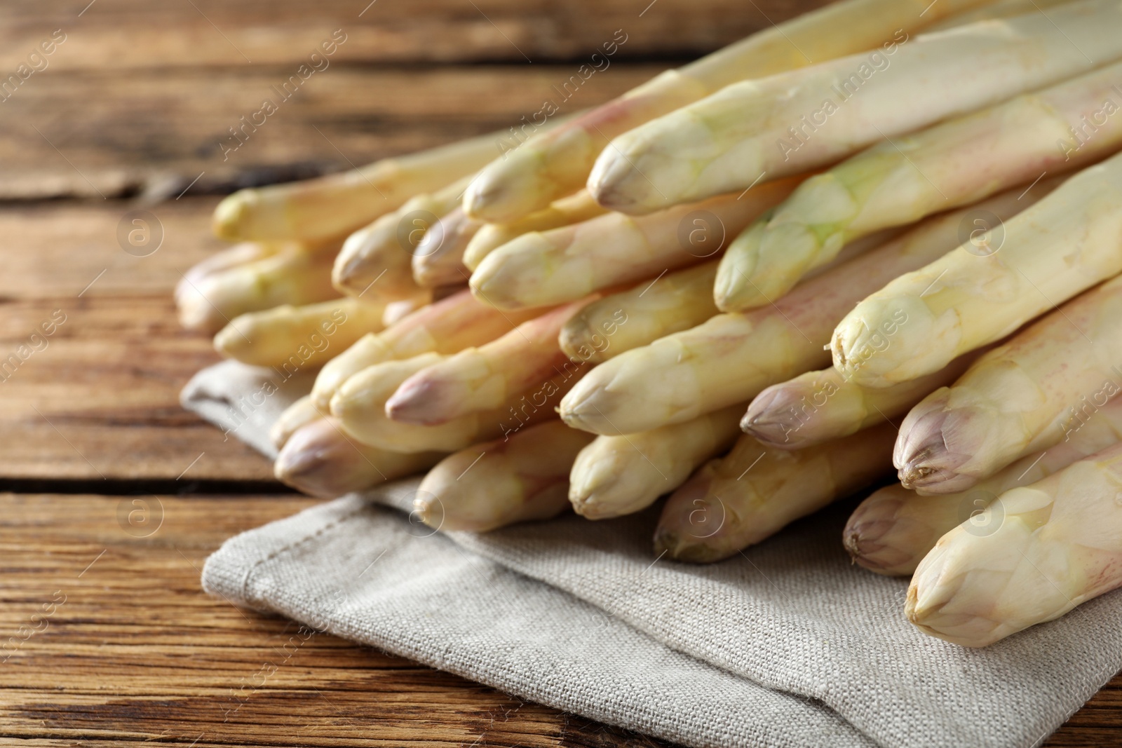 Photo of Fresh white asparagus on wooden table, closeup