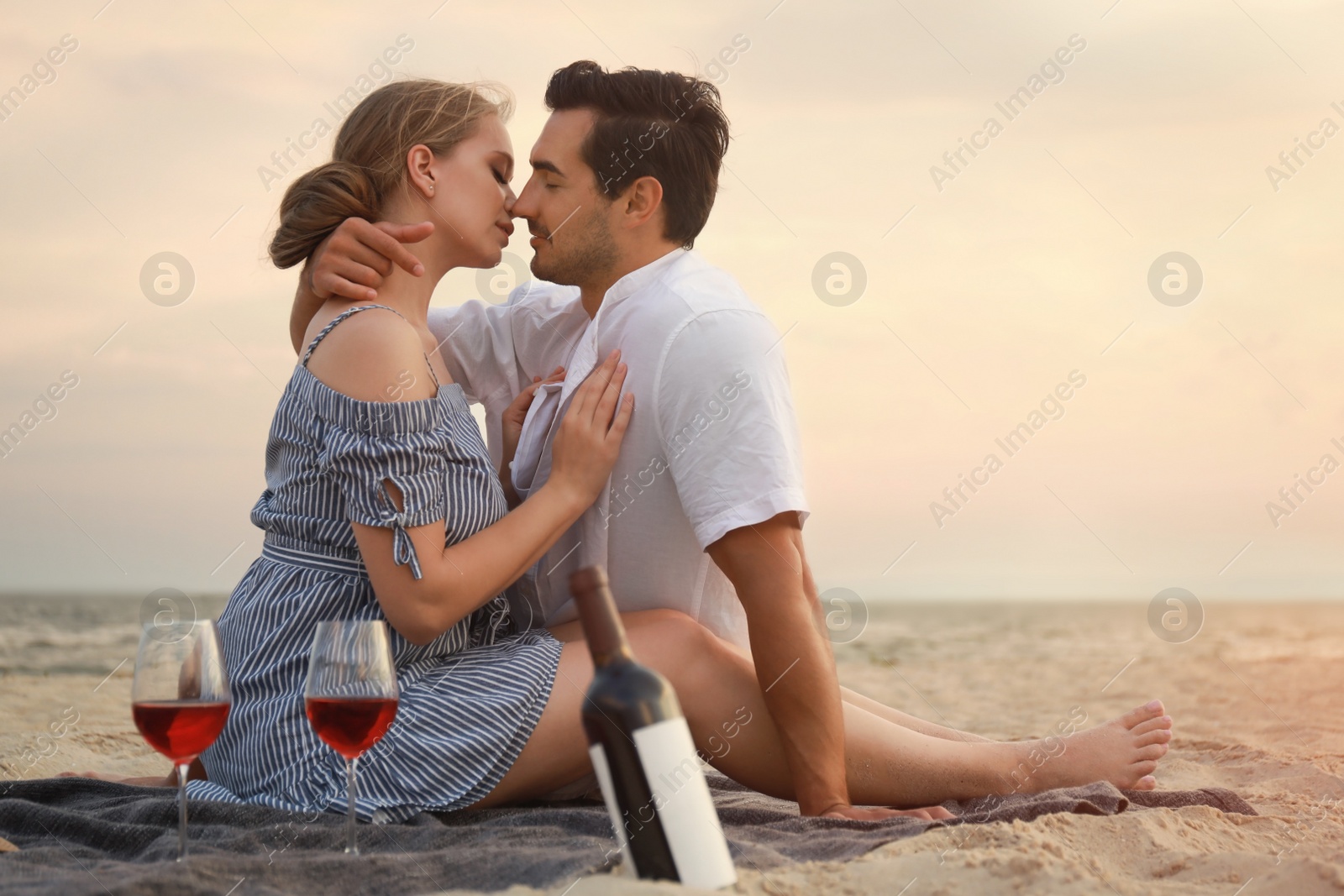 Photo of Happy young couple having picnic at sea beach