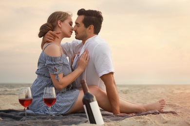 Happy young couple having picnic at sea beach