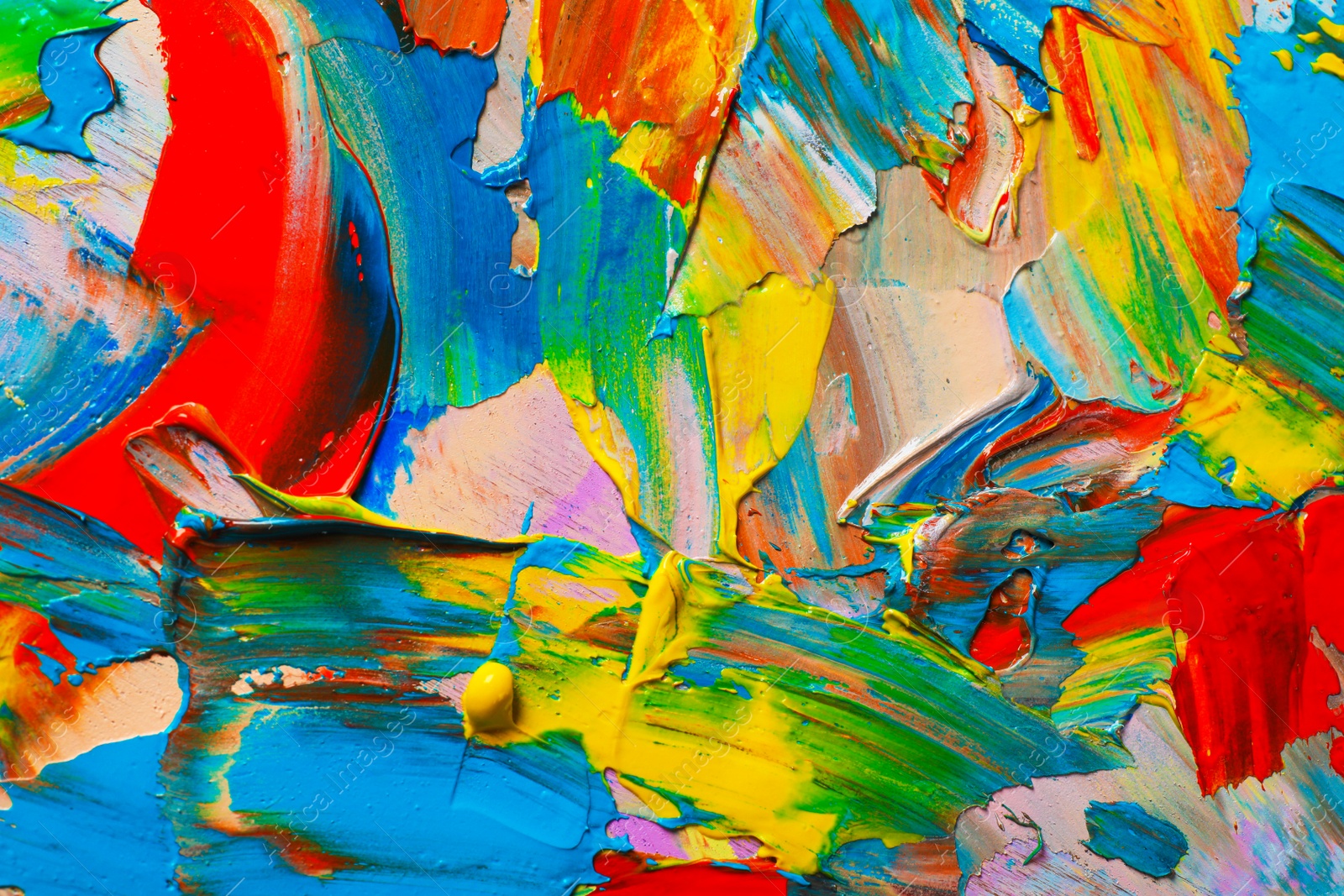 Photo of Closeup view of artist's palette with mixed bright paints as background