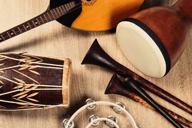 Photo of Set of different vintage musical instruments on wooden background, flat lay