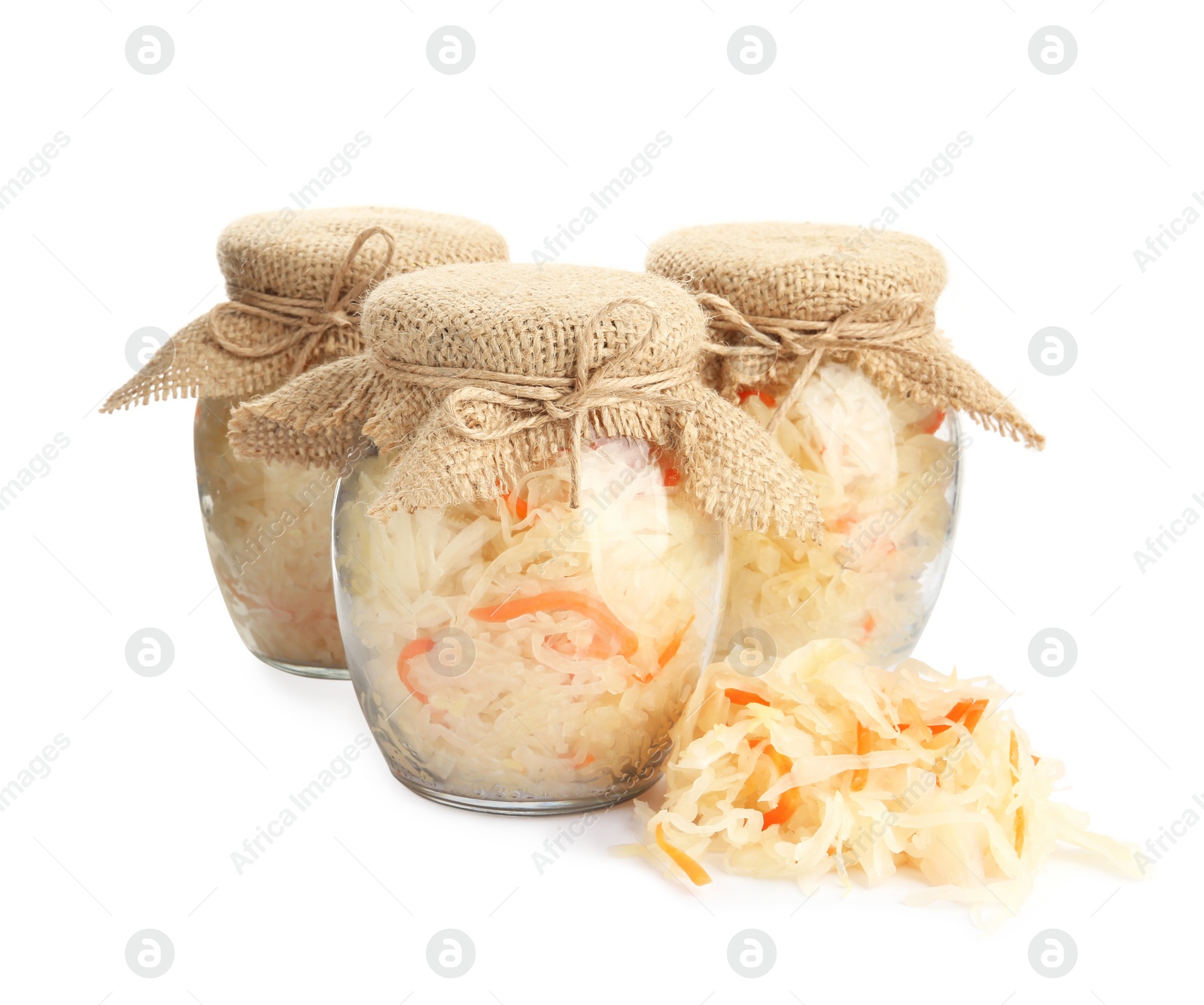 Photo of Glass jars of tasty fermented cabbage with carrot on white background