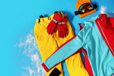 Photo of Stylish winter sport clothes on light blue background, flat lay