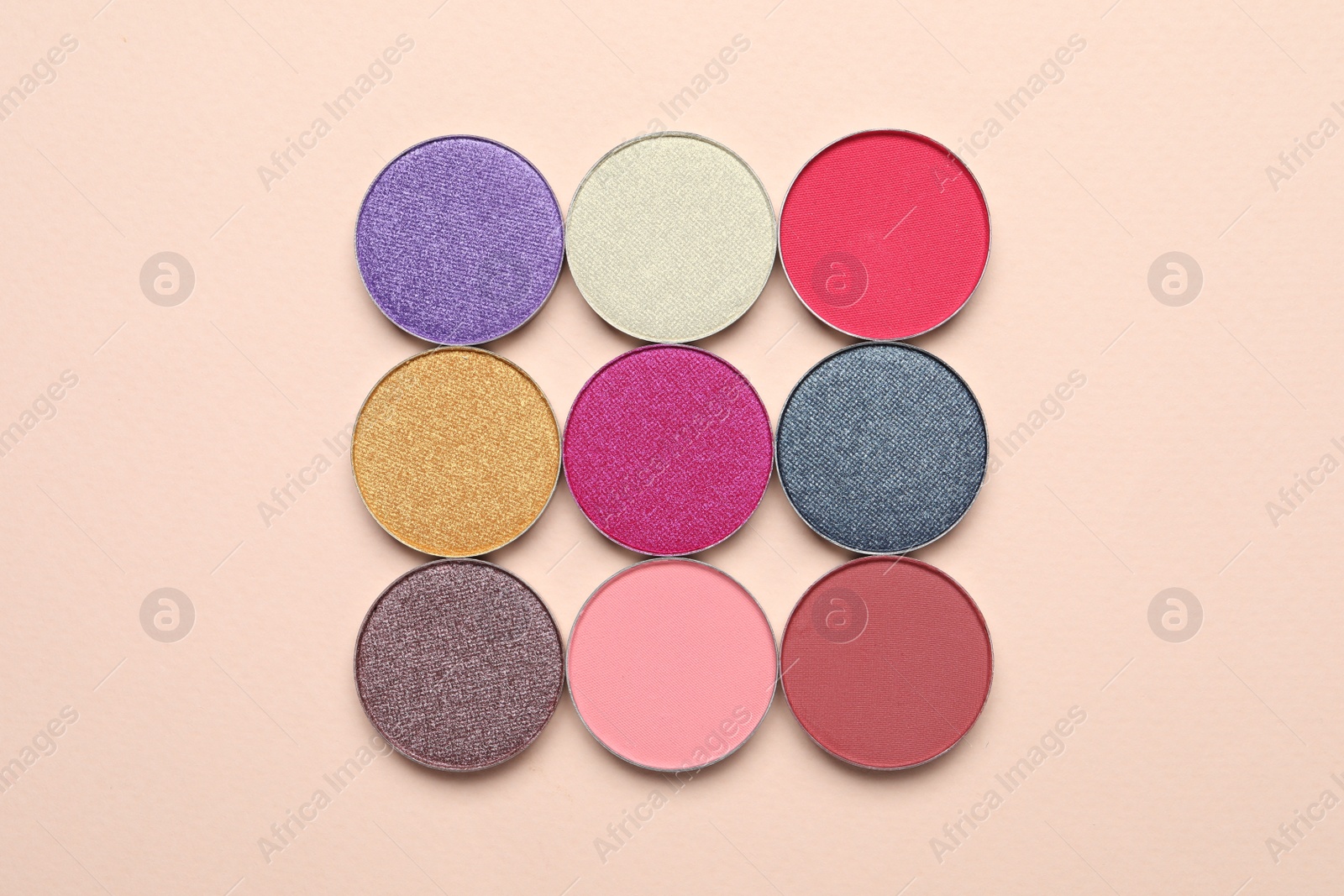 Photo of Beautiful eye shadow refill pans on beige background, flat lay