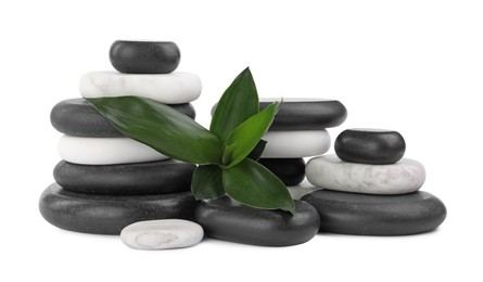 Photo of Stacks of spa stones and bamboo leaves on white background
