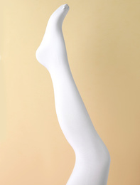 Photo of Leg mannequin in white tights on beige background