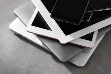 Photo of Many different modern gadgets on grey table, closeup