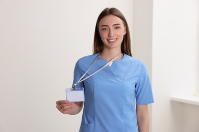 Happy doctor with blank badge in hospital