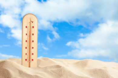 Image of Weather thermometer with high temperature and sandy beach on sunny day
