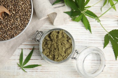 Hemp protein powder, seeds and fresh leaves on white wooden table, flat lay