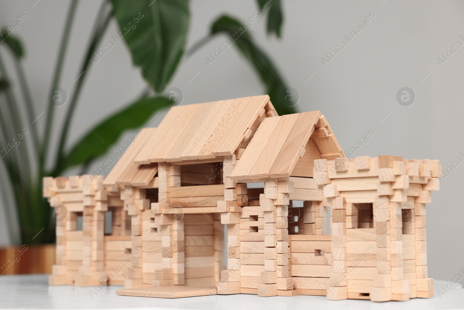 Photo of Wooden entry gate on white table against blurred background. Children's toy