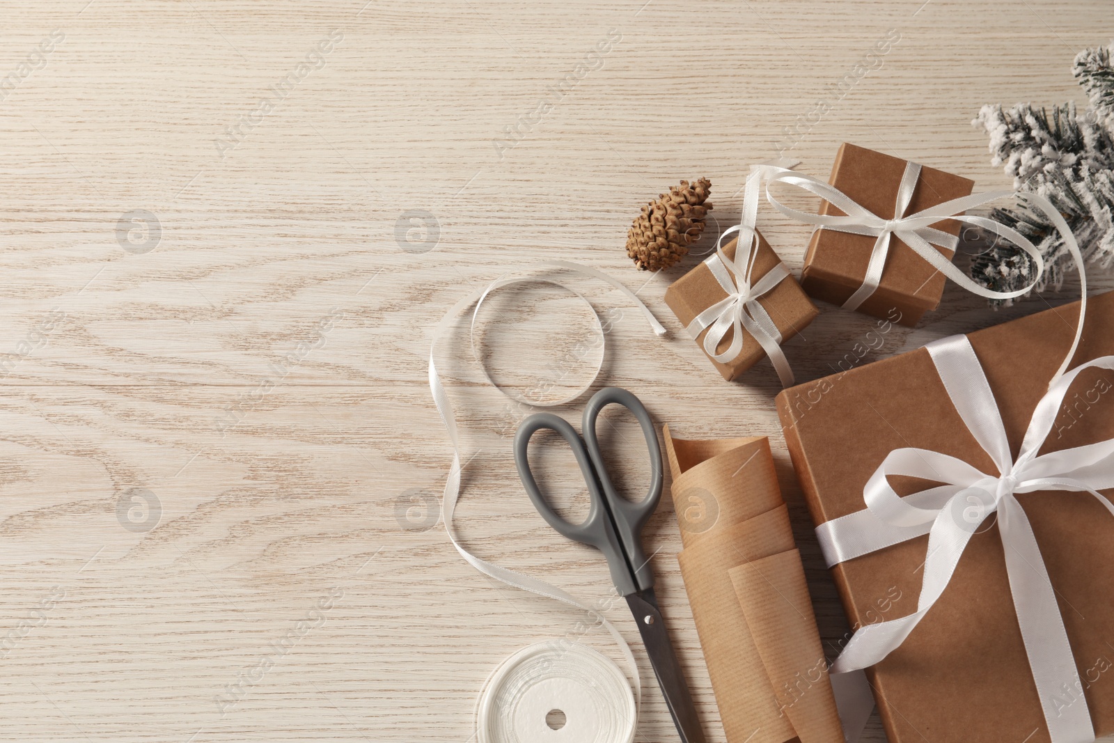 Photo of Flat lay composition with beautiful gift boxes and Christmas decorations on white wooden table. Space for text