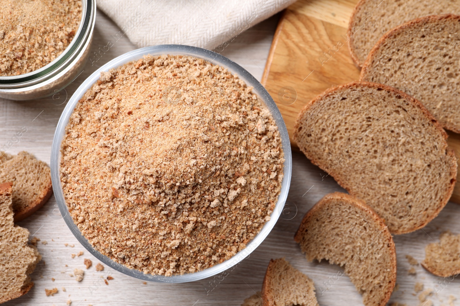 Photo of Fresh breadcrumbs on white wooden table, flat lay