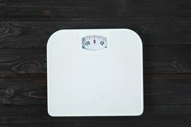 Photo of Scales on wooden background, top view. Weight loss