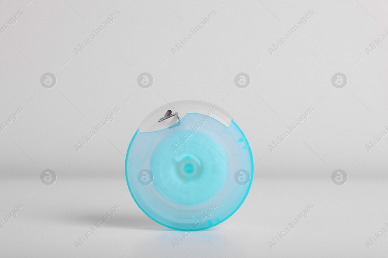 Photo of Container with dental floss on white background