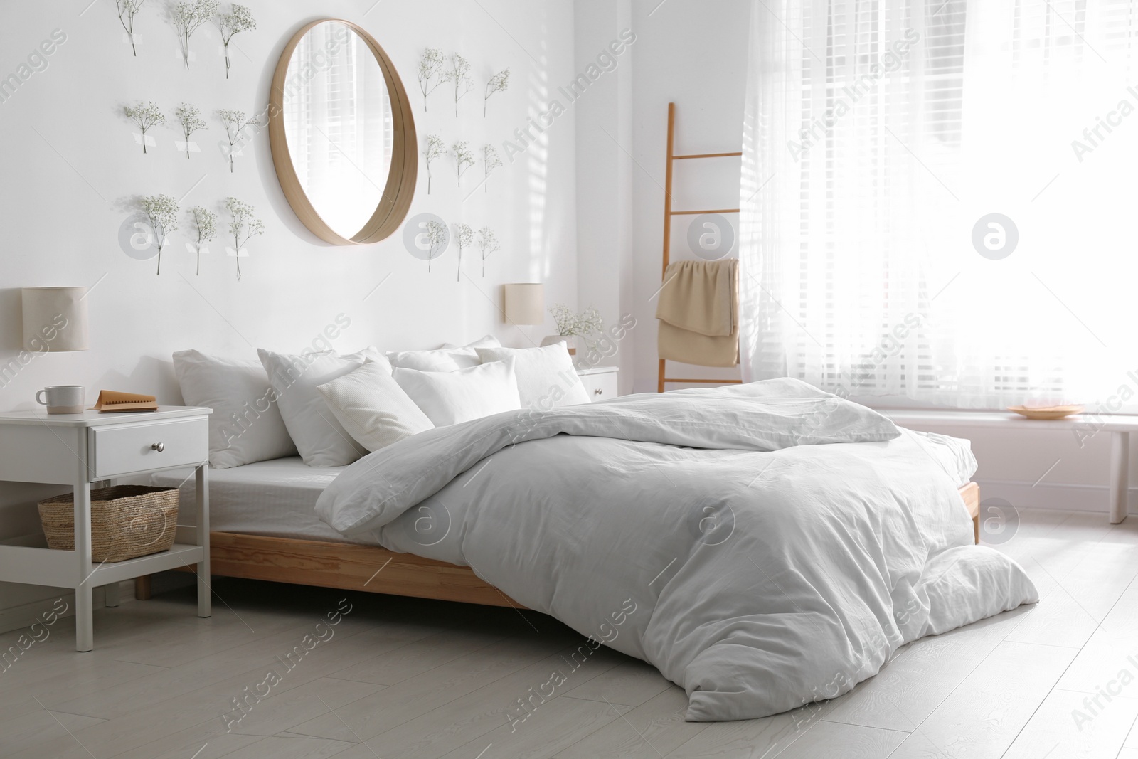 Photo of Modern bedroom interior with stylish round mirror