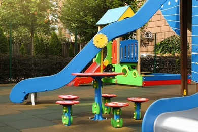 Photo of Outdoor playground for children with funny colorful table, chairs and slide