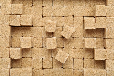 Brown sugar cubes as background, top view