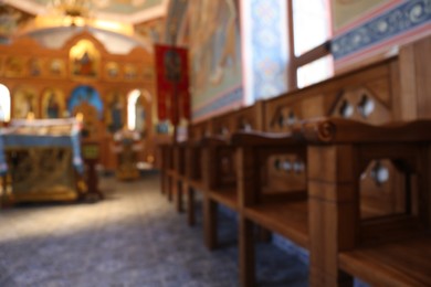 Photo of Blurred view of empty wooden benches in church