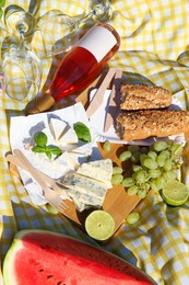 Photo of Delicious food and wine on picnic blanket, flat lay