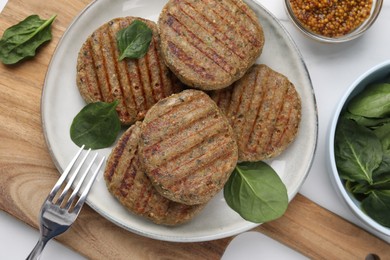 Photo of Tasty grilled vegan cutlets served on white table, flat lay