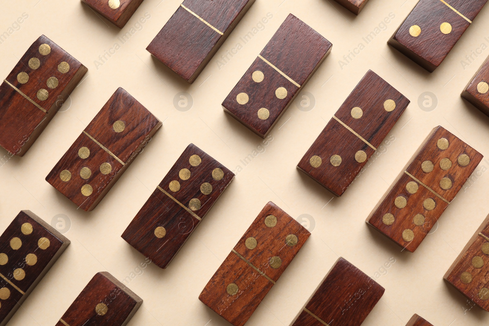 Photo of Wooden domino tiles on beige background, flat lay