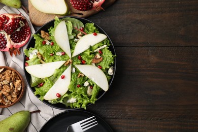 Photo of Delicious pear salad in bowl served on wooden table, flat lay. Space for text