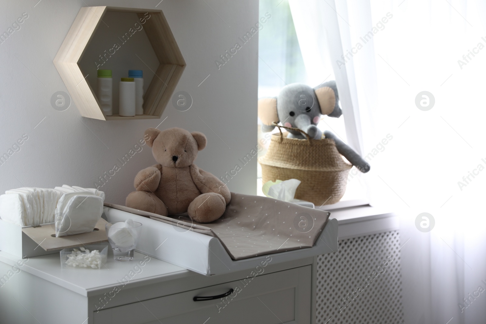 Photo of Modern changing table in baby room interior