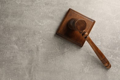 Photo of Wooden gavel on grey textured table, top view. Space for text