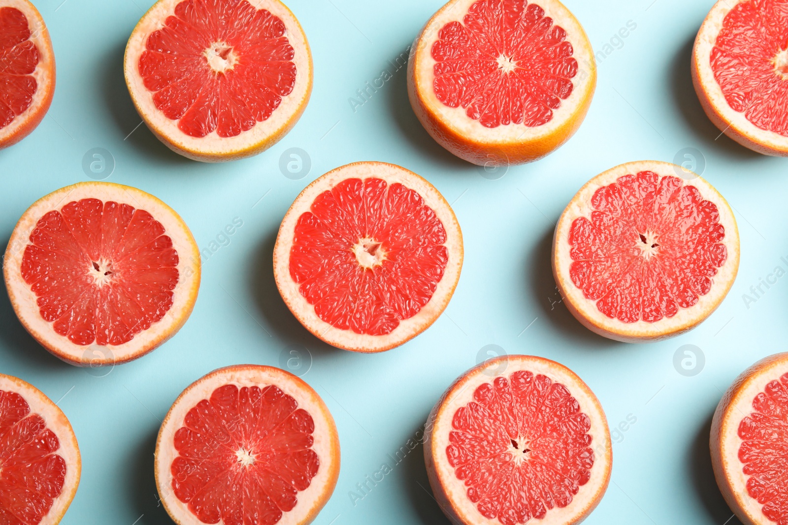 Photo of Fresh sliced ripe grapefruit on color background, flat lay