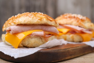 Photo of Delicious bagels with ham and cheese on table, closeup. Space for text