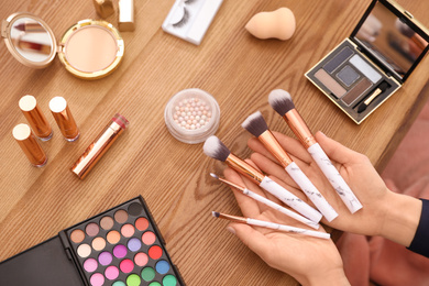 Photo of Beauty blogger with set of makeup brushes at table, closeup