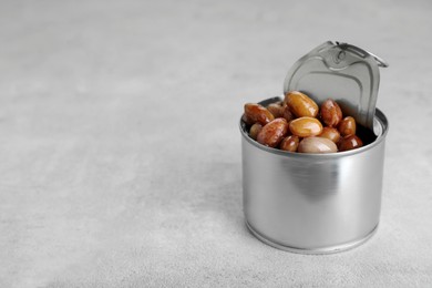 Photo of Tin can with kidney beans on light table, space for text