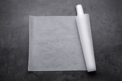 Roll of baking paper on grey table, top view
