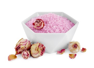 Photo of Bowl of pink sea salt and dry rose flowers isolated on white