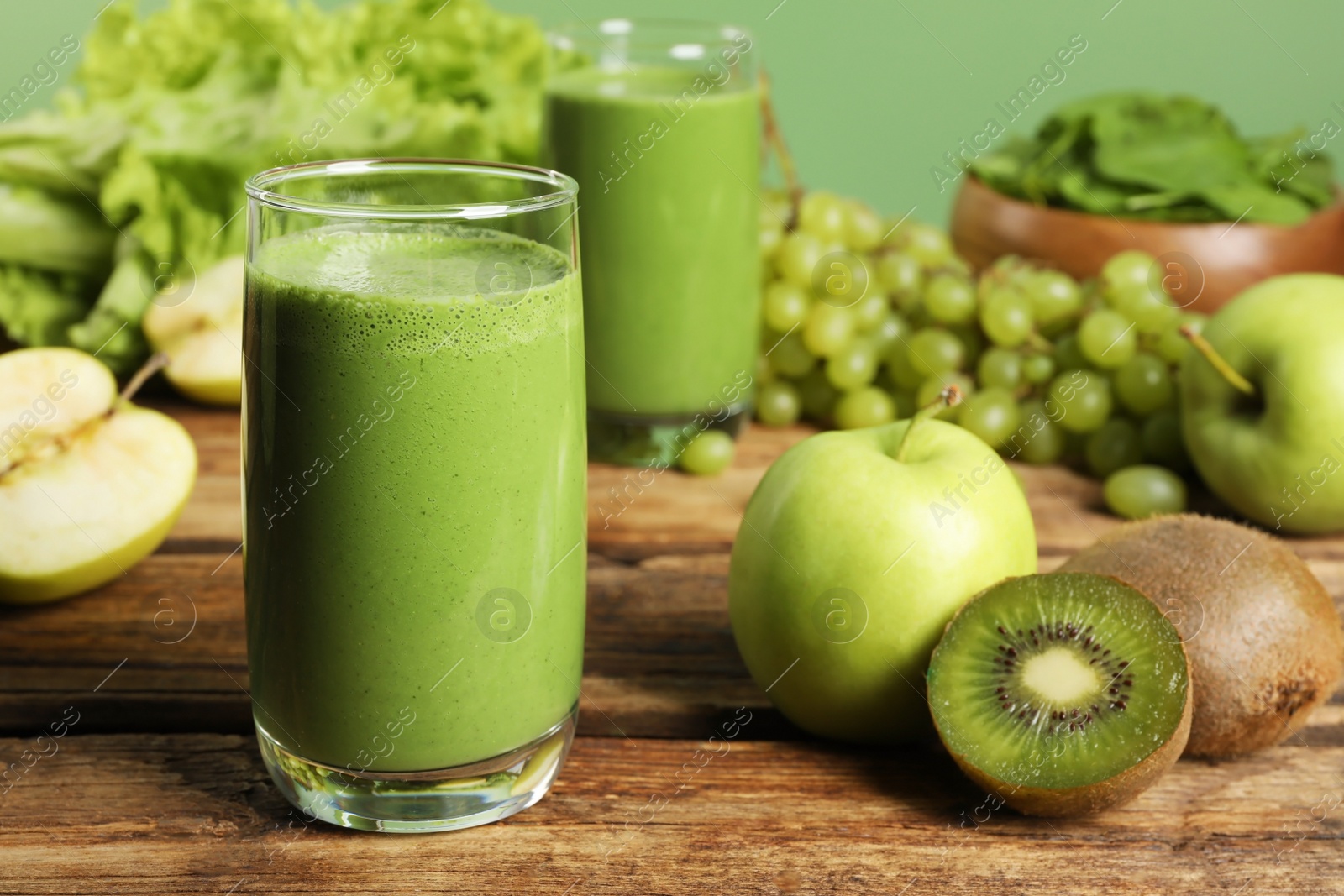 Photo of Green smoothie and fresh ingredients on wooden table