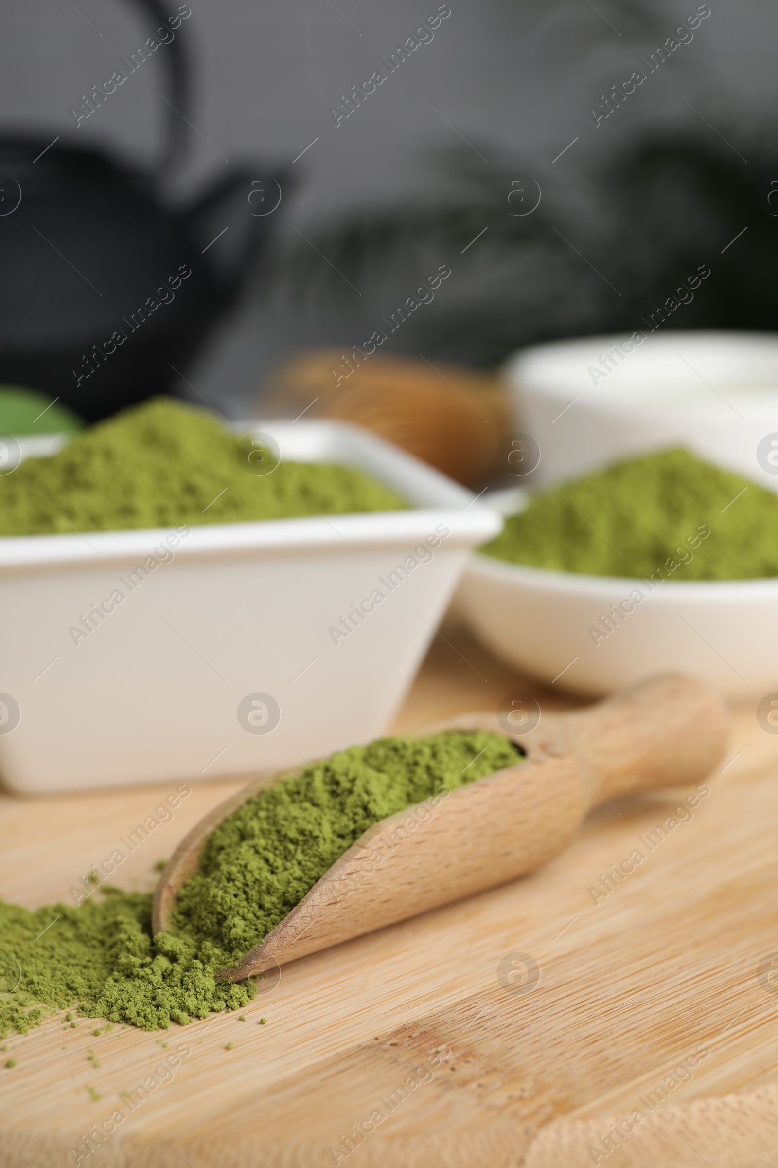 Photo of Green matcha powder on wooden board, closeup. Space for text