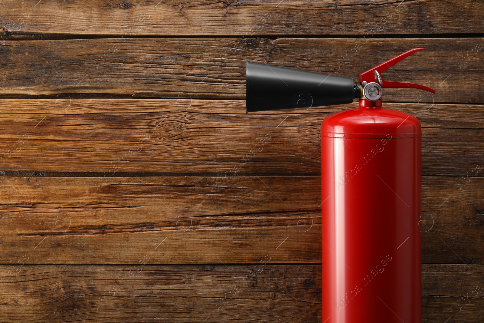 Photo of Fire extinguisher on wooden background, top view. Space for text