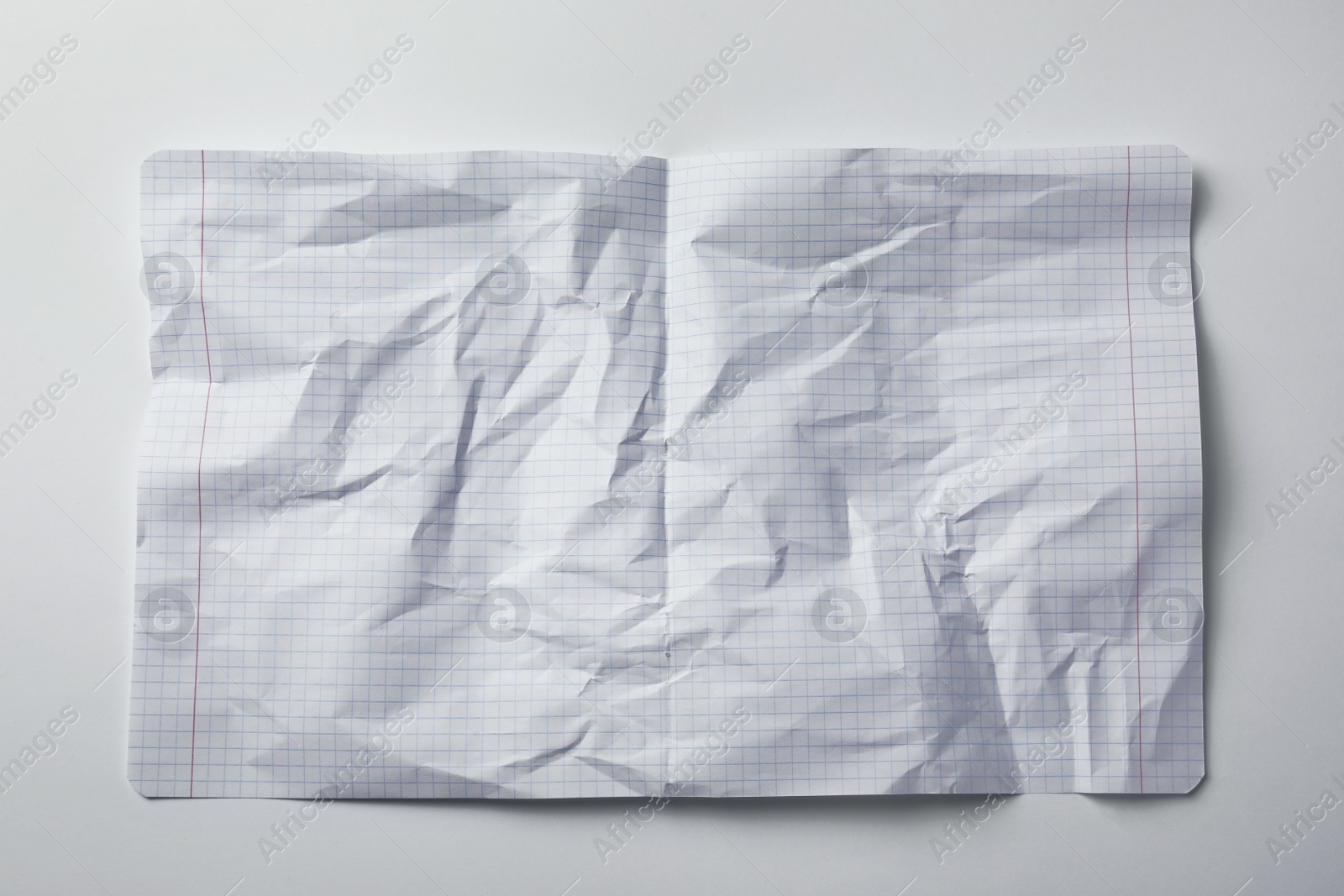 Photo of Crumpled sheet of paper on white background, top view