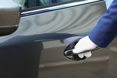 Photo of Closeup view of chauffeur opening car door