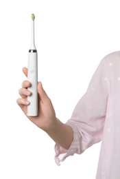 Woman holding electric toothbrush on white background, closeup