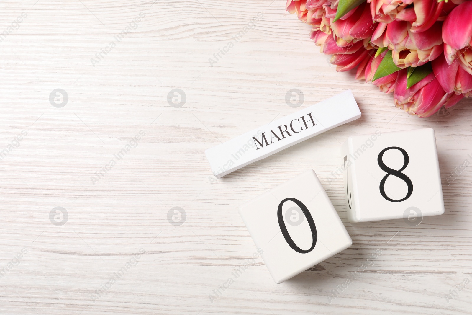 Photo of International Women's day - 8th of March. Block calendar and bouquet of beautiful tulips on white wooden table, flat lay. Space for text