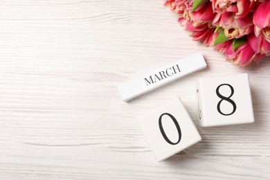 International Women's day - 8th of March. Block calendar and bouquet of beautiful tulips on white wooden table, flat lay. Space for text